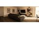 Modern living room with dark sofa, shelving unit and large TV at 13028 Cedar Elm Lane, Parrish, FL 34219
