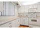 White kitchen with updated appliances and tile flooring at 1717 Pelican Cove Rd # 334, Sarasota, FL 34231
