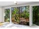Bright sunroom with sliding glass doors and view of lush garden at 1717 Pelican Cove Rd # 334, Sarasota, FL 34231