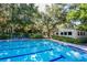Sparkling community pool with surrounding trees at 1717 Pelican Cove Rd # 334, Sarasota, FL 34231