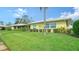 Light yellow single story home with green lawn and palm trees at 3712 Hampshire Ln # 5623, Sarasota, FL 34232