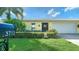 Front view of a yellow house with a white garage door and landscaping at 3712 Hampshire Ln # 5623, Sarasota, FL 34232