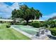 Outdoor shuffleboard courts with a shaded bench under a large tree at 3712 Hampshire Ln # 5623, Sarasota, FL 34232