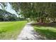 Pathway through lush trees and green grass along the golf course at 3712 Hampshire Ln # 5623, Sarasota, FL 34232