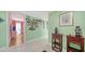 Hallway with light green walls, tiled floor, and wooden side tables at 3712 Hampshire Ln # 5623, Sarasota, FL 34232