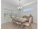 Bright dining room features a large table, chandelier, and plantation shutters at 4950 Kiva Cir, Bradenton, FL 34211