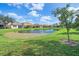 Community pond with homes and lush green lawns surrounding it at 6023 Wingspan Way, Bradenton, FL 34203