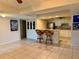 Open kitchen boasts white cabinets, tile backsplash and breakfast bar with two stools at 6447 Egret Ln # 413, Bradenton, FL 34210