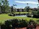 Scenic pond view with condo buildings, palm trees, and manicured lawn at 6447 Egret Ln # 413, Bradenton, FL 34210