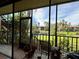 Serene screened porch overlooking a peaceful lake and lush landscape at 6447 Egret Ln # 413, Bradenton, FL 34210