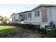 Backyard view of the home, with open windows and concrete porch at 840 Harvard St, Englewood, FL 34223