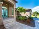 Front entry with teal door, stone steps, and landscaping at 85 Spaniards Rd, Placida, FL 33946