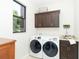 Laundry room with washer, dryer, cabinets, and a utility sink at 85 Spaniards Rd, Placida, FL 33946