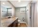 Bathroom with granite countertop, wood vanity, and tiled shower at 1521 Siesta Dr, Sarasota, FL 34239