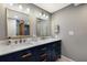 Double vanity bathroom with navy cabinets and gold accents at 1521 Siesta Dr, Sarasota, FL 34239