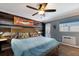King-size bed in a bedroom with wood accent wall and ceiling fan at 1521 Siesta Dr, Sarasota, FL 34239