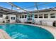 Inviting kidney-shaped pool with screened enclosure and patio at 1521 Siesta Dr, Sarasota, FL 34239