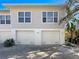 Three-car garage with light beige doors and a light beige exterior at 1827 Highland Rd, Osprey, FL 34229