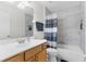 Updated bathroom featuring tiled walls, a modern vanity, and bathtub with modern shower curtain at 1868 Scarlett Ave, North Port, FL 34289