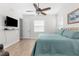 Bright bedroom with a ceiling fan, a television, a queen-sized bed, and wood laminate flooring at 1868 Scarlett Ave, North Port, FL 34289