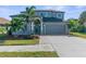 Charming two-story home with palm trees, a well-manicured lawn, and a two-car garage at 1868 Scarlett Ave, North Port, FL 34289