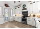 Charming kitchen with stainless steel appliances, white cabinets, and brick backsplash at 1868 Scarlett Ave, North Port, FL 34289