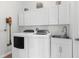 Convenient laundry room with modern washer, dryer, white cabinets, and utility sink at 1868 Scarlett Ave, North Port, FL 34289