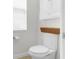 A clean, white toilet with a window and shelving above, in a well-lit bathroom at 1868 Scarlett Ave, North Port, FL 34289