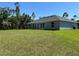 Home's backyard features well maintained lawn, and several windows providing natural light to the home at 3006 Chickasaw Ave, North Port, FL 34288
