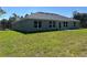 Home's backyard features well maintained lawn, several windows and backyard patio for relaxing at 3006 Chickasaw Ave, North Port, FL 34288