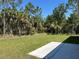 Backyard features well maintained lawn, spacious backyard with lush tropical trees at 3006 Chickasaw Ave, North Port, FL 34288