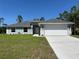 Charming single-story home with a two car garage, well maintained lawn, and a gray roof at 3006 Chickasaw Ave, North Port, FL 34288