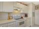 White kitchen cabinets, stove, microwave, and coffee maker at 381 Bobby Jones Rd # 381, Sarasota, FL 34232