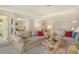 Open living room with two sofas, coffee table, and views of kitchen and patio at 381 Bobby Jones Rd # 381, Sarasota, FL 34232