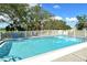 Community pool with a white fence and lush landscaping at 381 Bobby Jones Rd # 381, Sarasota, FL 34232