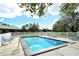 Sparkling community pool surrounded by a fenced area with lounge chairs at 381 Bobby Jones Rd # 381, Sarasota, FL 34232