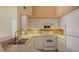 White kitchen with appliances and a double sink at 4134 Central Sarasota Pkwy # 1734, Sarasota, FL 34238
