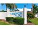 Entrance to Crestwood Villas with manicured landscaping and a vibrant flower bush at 5395 Christie Ann Pl # 9, Sarasota, FL 34233