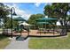 Community playground with slides and sunshade in a well-maintained outdoor recreation area at 5395 Christie Ann Pl # 9, Sarasota, FL 34233