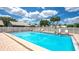 A refreshing in-ground pool surrounded by lounge chairs and white picket fence under a sunny sky at 5395 Christie Ann Pl # 9, Sarasota, FL 34233