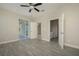 Bedroom with wood-look floors, ceiling fan and access to bathroom at 6227 Blue Runner Ct, Lakewood Ranch, FL 34202