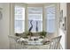 Bright breakfast nook features a glass-top table and window seat at 6248 Champions Row, Bradenton, FL 34210