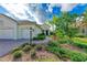 Front entrance with a walkway, landscaping, and a three-car garage at 1049 River Wind Cir, Bradenton, FL 34212