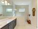 Modern bathroom with a double vanity, walk-in shower, and marble finishes at 1049 River Wind Cir, Bradenton, FL 34212