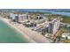 Expansive aerial view of beachfront condos with lush landscaping, a sparkling pool, and pristine sandy beach at 1102 Benjamin Franklin Dr # 409, Sarasota, FL 34236