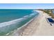 Scenic view of the beach with waves crashing on the shore and buildings in the distance at 1102 Benjamin Franklin Dr # 409, Sarasota, FL 34236
