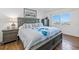 Comfortable bedroom with a large bed, dresser, nightstands, bright window, and wood-look floors at 1102 Benjamin Franklin Dr # 409, Sarasota, FL 34236
