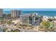 A multi-story building with palm trees, manicured landscaping, and ocean views from a scenic neighborhood street at 1102 Benjamin Franklin Dr # 409, Sarasota, FL 34236