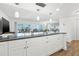 Bright kitchen with granite counters, modern lighting, and plenty of cabinet space with views to the living area at 1102 Benjamin Franklin Dr # 409, Sarasota, FL 34236