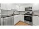 Modern kitchen features stainless steel appliances, granite countertops, a tiled backsplash, and wood look flooring at 1102 Benjamin Franklin Dr # 409, Sarasota, FL 34236